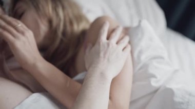 Yatakta yavaşça kucaklaşan şehvetli bir çiftin portresi. Tutkulu erkek ve kadın şehvetli ön sevişmeden zevk alıyorlar. Yatak odasında iç çamaşırlı seksi amatörler öpüşüyor. Cinsel ilişki kavramı.