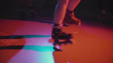 Karanlık stüdyoda paten üzerinde dans eden bir grup milenyum. Gençler birlikte zaman geçiriyorlar, hareketlerini sergiliyorlar, iyi vakit geçiriyorlar. Gece hayatı gençlik kültürüne bir bak. Yaşam tarzı kavramı.