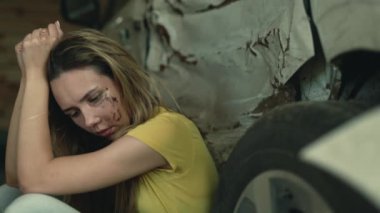 Kaza anında yolda oturan yaralı kız. Yüzünde yara izi olan stresli mutsuz bir kadın. Araba kazası kurbanı. Felaket, yaralanma, ilk yardım ve 911. Tehlikeli sürüş.