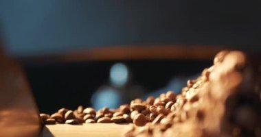 Kavrulmuş kahve çekirdekleri uçar ve ağır çekimde siyah bir arka planda döner. Taze kızarmış kahve çekirdekleri üretim fabrikası. Soğutma tabağında hazır kahve çekirdekleri..