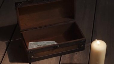 Mistik esrarengiz ayin sahnesi. Falcı kadın kehanetten sonra tarot kartlarını tahta kutuya koyuyor. Karanlık bir yerde, kafatası ve mumla korkunç mistik bir atmosfer. Ayin kavramı, okültizm.