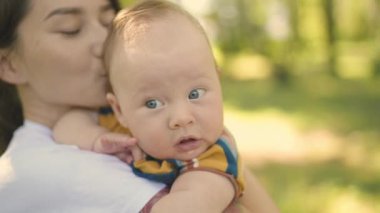 Güneşli bir günde parkta yürürken elinde küçük sevimli bir bebekle bir anne. Çocuk dünyayı ve çevreyi keşfediyor, ebeveynlerle doğayı deneyimliyor, etrafa bakıyor..