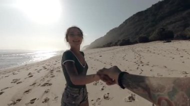 Kumsalda koşan mutlu kız. Beni takip edin. Kumsalda koşan çekici bir kızın portresi, deniz kıyısında hareket eden bir erkeğin başrol oyuncusu. Rahatlama ve sevgi kavramı