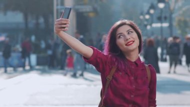 Güzel genç bir kadın dışarıda selfie çekiyor. Güzel bir Asyalı kız yazı Avrupa 'da tatilde geçirir. Kız mutlu ve hayattan zevk alıyor. Bir kadın Avrupa sokaklarında yürüyor. Arkadaşlık ve