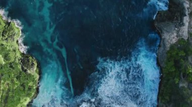 Denizdeki tropikal adalarda yukarıdan aşağıya muhteşem bir manzara. Güzel gök mavisi suyun, ağaçlı kayalık uçurumların inanılmaz renkli manzarası. Huzurlu bir rahatlama ve cennet. Seyahat kavramı.