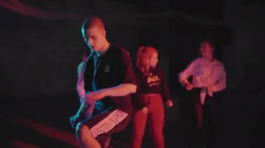 Patenli adam dans figürleri yapıyor. Karanlık stüdyoda spot ışıkları altında kayarken break dans yapan bir adam. Gece yaşam tarzının bir parçası olarak aşırı hareketlilik. Gençlik kavramı, gece hayatı.