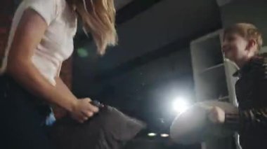 Genç sarışın anne çocuğuyla eğleniyor. Mutlu Avrupalı anne ve genç oğul yastık savaşı ve kendini tecrit ve karantina sırasında yatakta zıplama. Çocukluk, annelik ve aile kavramı.