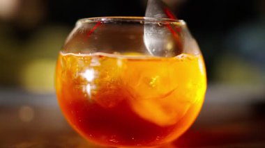 Profesyonel bir barmen, barda veya disko kulübünde müşterilere buz küplü alkollü bir kokteyl hazırlıyor. Profesyonel bir barmene yakın plan alkollü kokteylle profesyoneli karıştırmaktır.