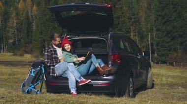 Toplumsal uzaklık. Uzun karantina sonrası yolculuklarında olan sevimli hippi genç bir çift. Güzel aşıklar harita üzerinde çalışıyorlar ve tatilleri boyunca arabada oturuyorlar..
