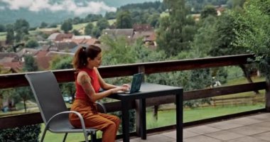 Tecrit karantinası. Sosyal mesafe çalışıyor. Asyalı kadın bahçede tek başına oturuyor ve dizüstü bilgisayarla çalışıyor. Güzel bayan dışarıda bilgisayarla tarrace üzerinde temiz havanın ve yalnızlığın tadını çıkarıyor..