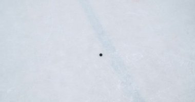 YAROSLAVL, RUSSIA - 29 Ocak 2015: buz hokeyi sopası ve buz hokeyi diski. Genç gençler bahçede hokey oynarlar. Diski sürüyorlar, çatışmaya giriyorlar, paten kayıyorlar. İki kardeş ve kış eğlencesi Okul buz pistinde