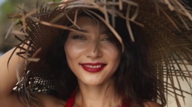 Karışık ırk bayanı tatilini tropik ada kayalık mağaralarında geçiriyor. Bali egzotik atmosferi. Güzel Asyalı kadın kırmızı elbiseyle tropikal beyaz kumsalda yürüyor. Güzellik, seyahat, moda konsepti.