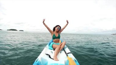 Güneş gözlüklü genç bir kadın teknede dinleniyor. Tayland 'da turizm ve eğlence. Yakışıklı Asyalı kadın adaları geziyor. Kız hayattan zevk alıyor ve eğleniyor. Cennet kumsalları ve beyaz kum