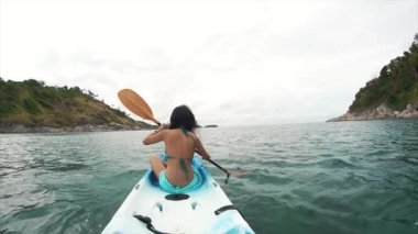 Kanoyla kürek çeken gezgin kadın. Tayland 'da turizm ve eğlence. Yakışıklı Asyalı kadın adaları geziyor. Kız hayattan zevk alıyor ve eğleniyor. Cennet kumsalları ve beyaz kum