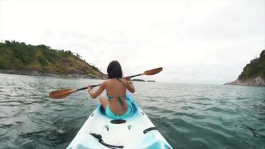 Kanoyla kürek çeken gezgin kadın. Tayland 'da turizm ve eğlence. Yakışıklı Asyalı kadın adaları geziyor. Kız hayattan zevk alıyor ve eğleniyor. Cennet kumsalları ve beyaz kum