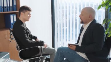 Ofis geçmişiyle sohbet eden iki iş adamının portresi. Takım elbiseli sıradan adamlar fırsatları ve yaklaşan projeleri tartışıyor. Röportaj kavramı, anlaştık..