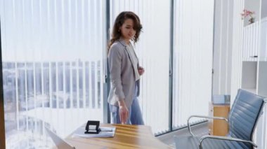 Masasının etrafında yürüyen ve sandalyede oturan güzel kadın ofis çalışanının portresi. Ofis değişimi sahnesi ve iş arkadaşları arasında küçük sohbetler.