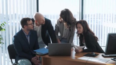 Bir grup genç ofis çalışanı yaklaşan sunum stratejisini tartışıyor. Takım toplantısı sırasında iş arkadaşları beyin fırtınası yapıyor. Takım oluşturma kavramı.