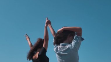 Mavi gökyüzüne karşı kolları açık duran kızlar. En iyi arkadaşlar yazı birlikte geçirirler. Kızlar mutlu ve hayattan zevk alıyorlar. Arabayla denize giden yol. Sonsuza dek dostluk ve sevgi. Güzelliğin