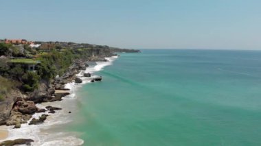 Alex Drone 'un muhteşem deniz manzarası. Ağaçların arasına hortumların yerleştirildiği kayalık kıyılarda mavi dalgalar kırılıyor. Parlak bir günde insansız hava aracı tarafından vurulan tropik deniz manzarası. Seyahat kavramı, egzotik, manzara.