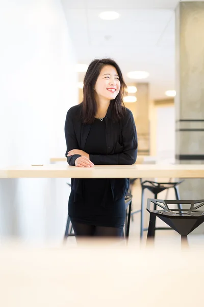 Kampüsü'ndeki yüksek masada duran Asya kolej öğrenci