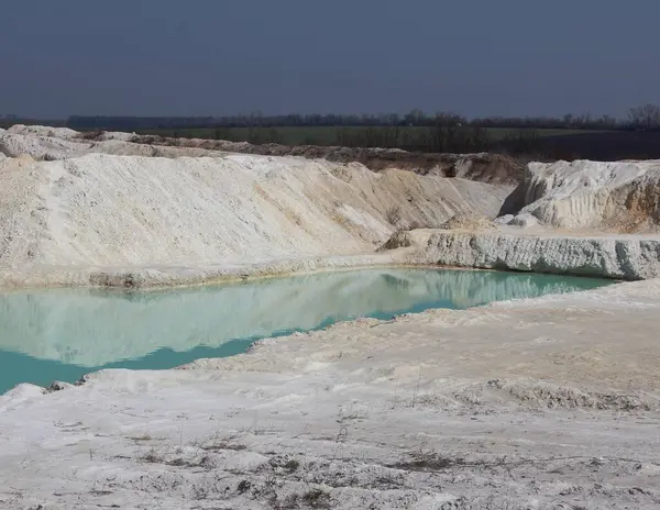 Klei mijnbouw. Mooie achtergrond van witte klei. Blauw water. — Stockfoto