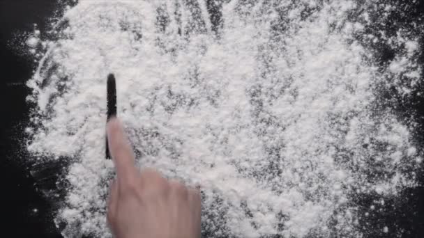 En hand skriva på vitt mjöl — Stockvideo