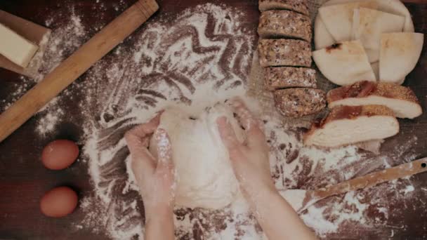 Mains pétrissant la pâte crue sur la table — Video