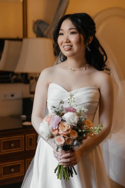 Lüks, klasik iç mimarisi olan zarif, beyaz elbiseli güzel bir Asyalı gelin. Yüksek kalite fotoğraf