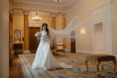 Lüks, klasik iç mimarisi olan zarif, beyaz elbiseli güzel bir Asyalı gelin. Yüksek kalite fotoğraf