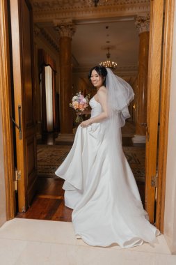 Lüks, klasik iç mimarisi olan zarif, beyaz elbiseli güzel bir Asyalı gelin. Yüksek kalite fotoğraf