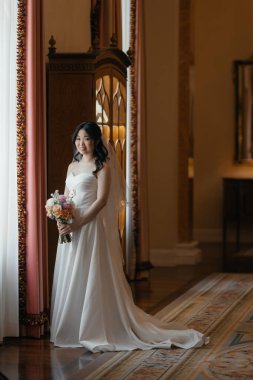 Lüks, klasik iç mimarisi olan zarif, beyaz elbiseli güzel bir Asyalı gelin. Yüksek kalite fotoğraf