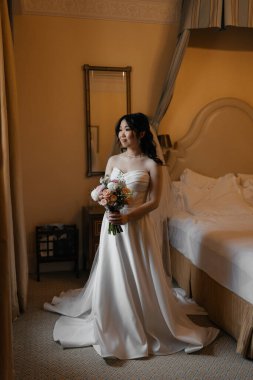 Lüks, klasik iç mimarisi olan zarif, beyaz elbiseli güzel bir Asyalı gelin. Yüksek kalite fotoğraf