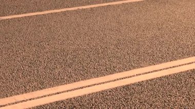 Güneşli gökyüzünün altındaki boş asfaltta çift katlı yol işareti. Yüksek kalite 4k görüntü