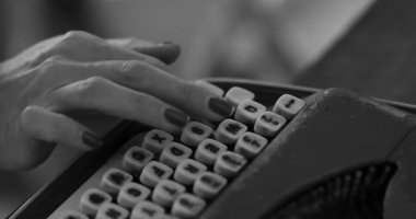  Kadın eski mavi bir daktiloyla yazı yazıyor. Mektuplar anahtarlara kazınmış. Çerçevesinde kırmızı tırnak askılı bir kızın elleri var. Bir kitap yazıyor. İçeride. Yüksek kalite 4k görüntü