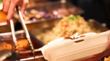 Yoğun yemek reyonunda Asya mutfağı servis eden yemek maşaları servis ediliyor. Yüksek kalite 4k görüntü