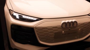 Dubai, BAE, 30 Nisan 2025: Sıcak altın ışıkla aydınlatılmış en yeni Audi Q6 e tron ön tasarımı. Modern elektrikli SUV yeniliği, zarafeti ve lüks geleceği simgeliyor. Yüksek kalite 4k görüntü