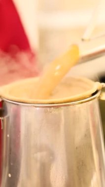 Uzun çaydanlıktan metal süzgeç bardağına dökülen Asya çayını kapatın. Yüksek kalite 4k görüntü