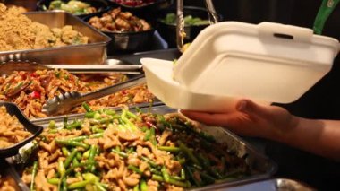 Öğle yemeği için beyaz servis konteynırında servis edilen karışık sebze sokak yemekleri.