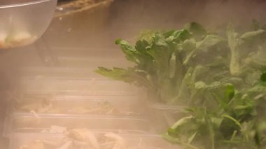 Taze yeşil yapraklı sebzeler ve mantarlar süpermarket buzdolabında düzgünce dizilmiş. Yüksek kalite 4k görüntü