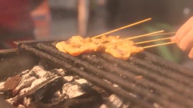 Asya 'daki bir sokak yemekhanesinde açık ateşte ızgara yapan pek çok küçük şiş yemek atmosferi yaratır. Aşçılık projeleri için mükemmel bir ortam. Görsel seyahat ve canlı yaşam tarzı temaları. Yüksek kalite 4k görüntü