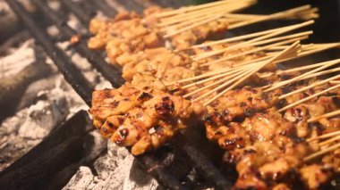 Asya 'daki bir sokak yemekhanesinde açık ateşte ızgara yapan pek çok küçük şiş yemek atmosferi yaratır. Aşçılık projeleri için mükemmel bir ortam. Görsel seyahat ve canlı yaşam tarzı temaları. Yüksek kalite 4k görüntü