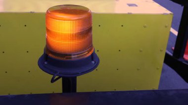 Bir kehribar uyarı ışığı. Hızla dönen bir teşhirci ile donatılmış. Yol yapım sinyali olarak kullanılıyor. Uyarı ışığı, yol yapım ışığı ışığı, kehribar teşhircisi hızla dönüyor. Ağır çekim. Işık. Yüksek kalite 4k görüntü