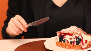 Çilek dolu kruvasan çatal bıçak ve tabakta ellerle yeniyor. Yüksek kalite 4k görüntü