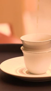 Gümüş Arap çaydanlığı küçük geleneksel fincan yakın çekim sahnesine çay döküyor. Yüksek kalite 4k görüntü