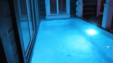 Gece açık yüzme havuzunda, yansımaları rahat atmosferik manzarayla aydınlatılmış. Yüksek kalite 4k görüntü