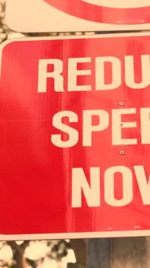 trafik ışığı yakınında hızı azaltmak için beyaz metin ile dikdörtgen yol işareti