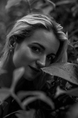 Yeşil yapraklarla çevrili güzel sarışın bir kızın yakın plan portresi. O modern bir saç stili giyiyor. Kuaförler ve kuaförler için. Konsept doğal güzellik. Yüksek kalite fotoğraf