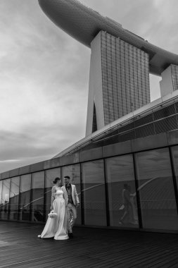 Gelin ve damat, Singapur şehrinin arka planına karşı. Güneşin doğuşu düğün fotoğrafı. - Evet. Yüksek kalite fotoğraf