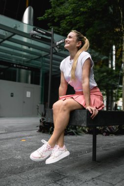 Singapur, 14 Şubat 2023: Pembe etekli, beyaz tişörtlü, uzun sarı saçlı çekici bir kız Singapur, Çin Mahallesi 'nin turistik bölgesinde yürüyor. Yüksek kalite fotoğraf